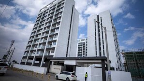 A multi-story building with a modern architectural design, featuring a prominent entrance and a visible name sign.