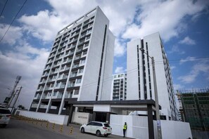 Un edificio de varios pisos con diseño arquitectónico moderno, que destaca una entrada principal y una señalización visible.