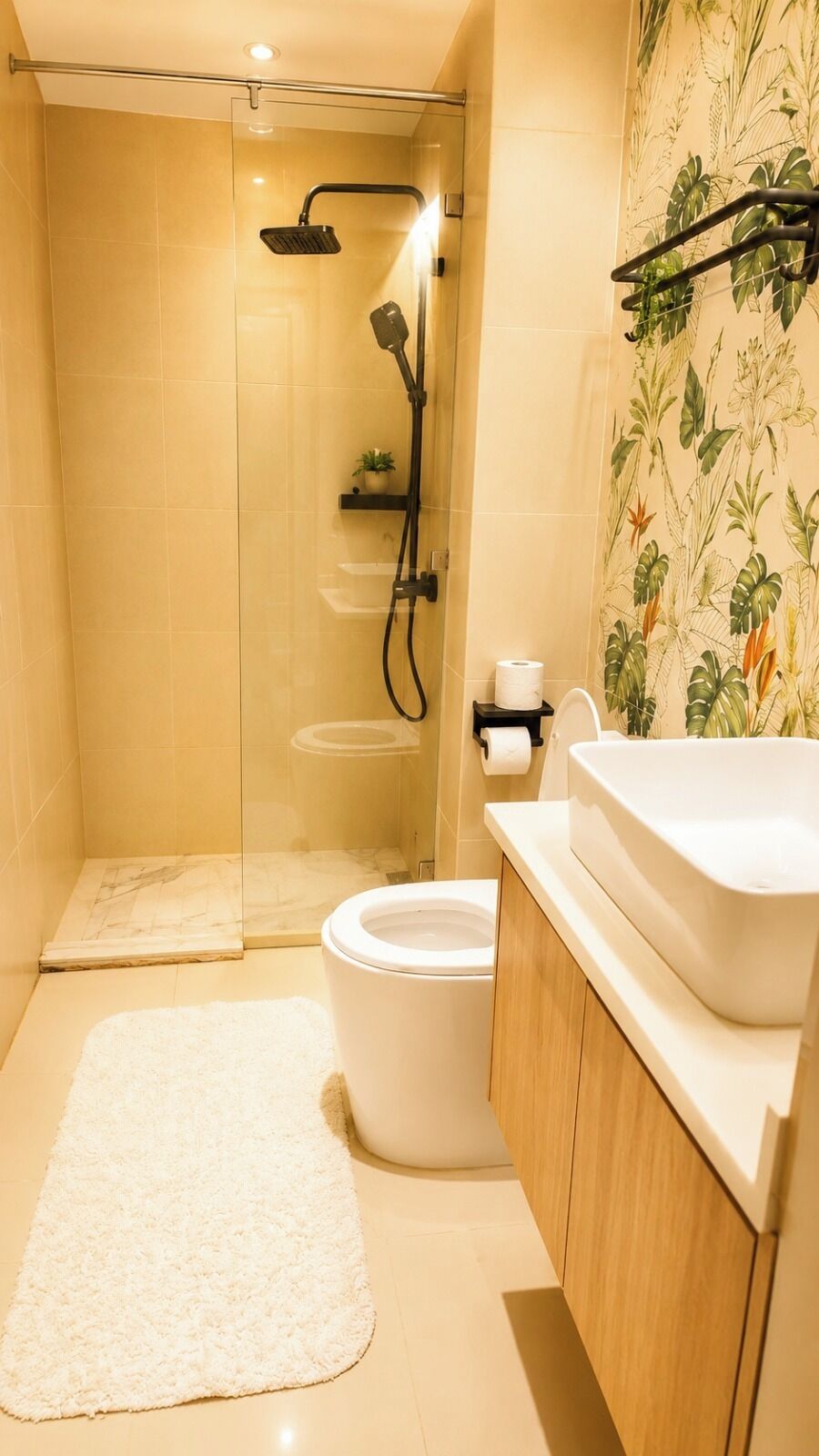 Une salle de bain avec douche, toilettes et lavabo.