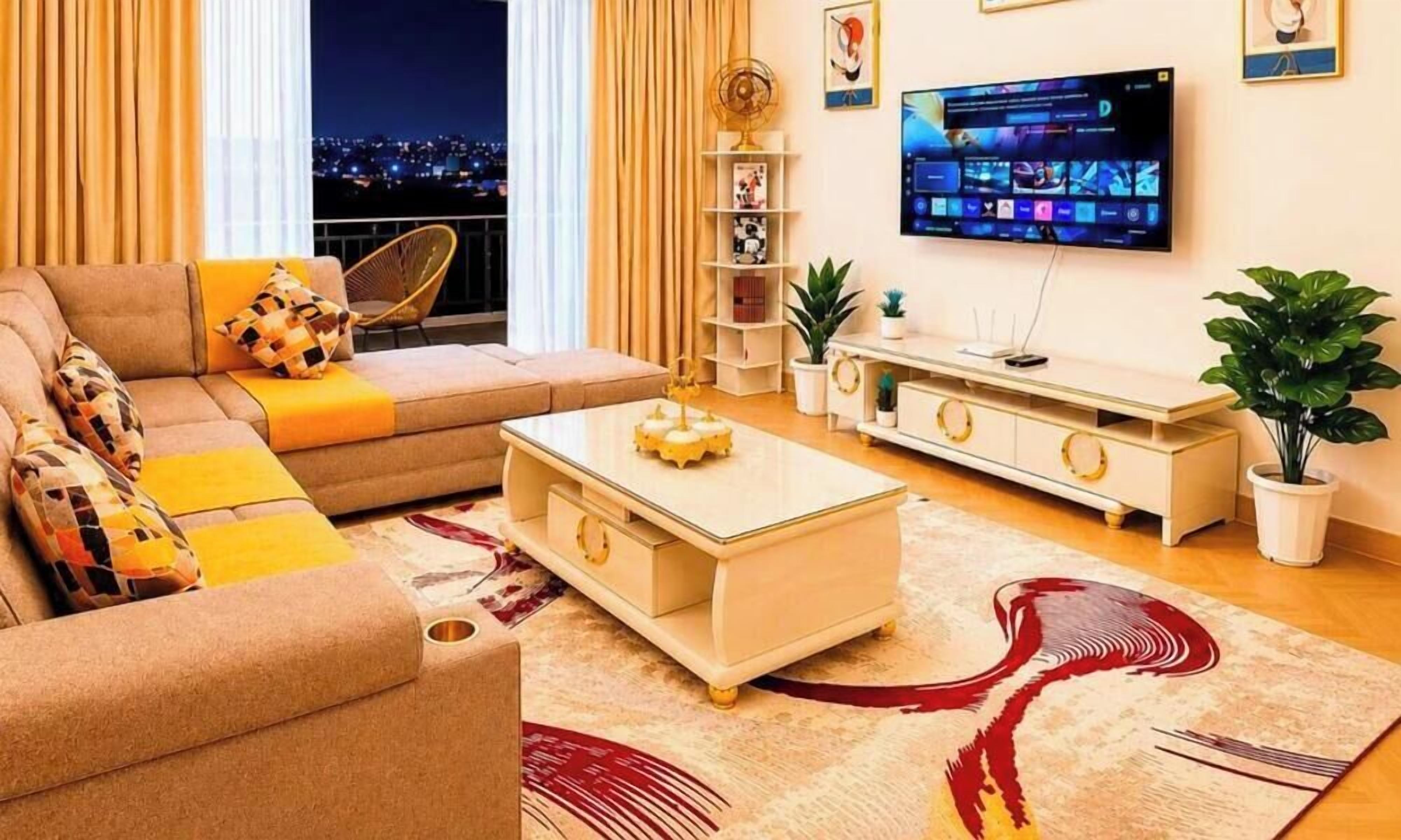 A living room with a sofa, coffee table, TV, and decorative items.