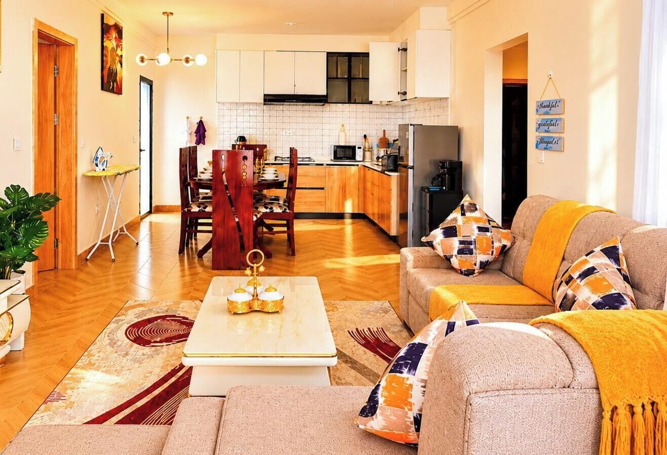 Una sala de estar moderna con un conjunto de sofás, una mesa de centro y un comedor con sillas y una mesa.