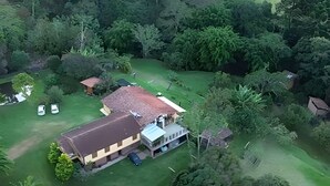 Una casa con un patio delantero amplio, un garaje y un cobertizo pequeño.