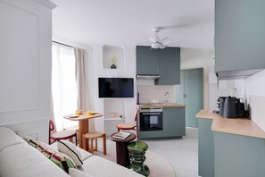 Eine moderne Wohnung mit Wohnbereich, Küchenzeile und Essplatz.