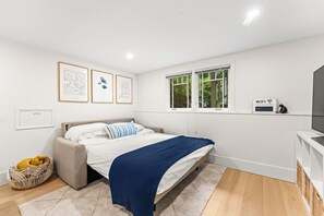 Ein Schlafzimmer mit Bett, Fenster, einem an der Wand befestigten WLAN-Schild und gerahmten Bildern.