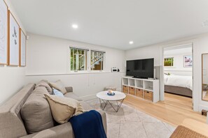 Ein modernes Wohnzimmer mit einer Couch, einem Fernseher und einem kleinen Tisch.