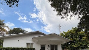 A single-story house with a front porch, a small garden, and a mailbox. - Modern Home • Walk to Design Dist• Free Parking (Miami)