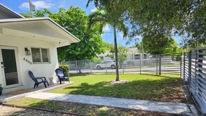 A residential property with a white house, a paved driveway, a gravel area, and a white fence. - Modern Home • Walk to Design Dist• Free Parking (Miami)