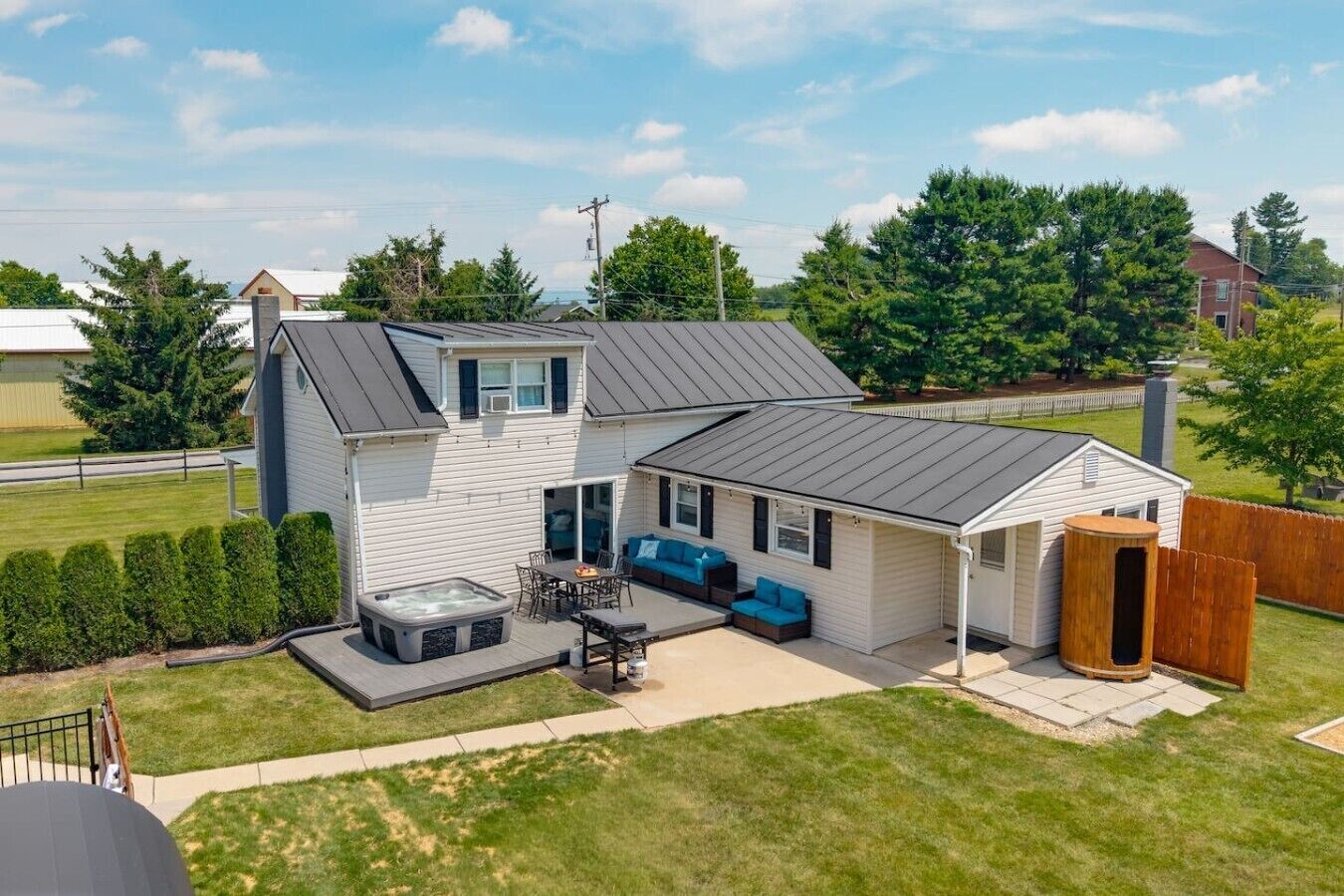A two-story house with a patio, hot tub, and outdoor seating area.