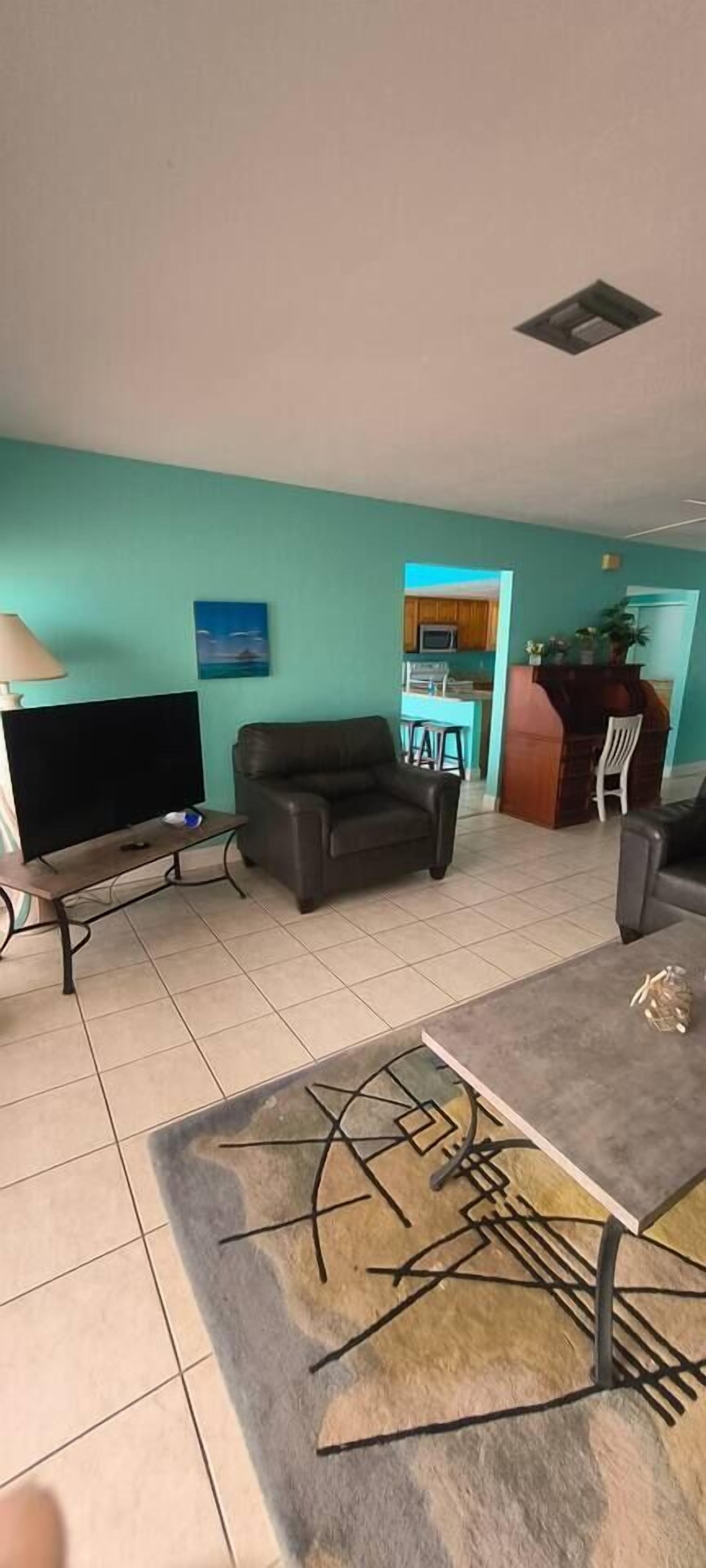A living room with a sofa, a coffee table, and a television.