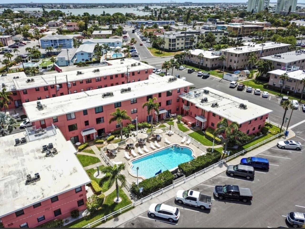 A multi-story hotel with a rooftop pool and a parking lot.