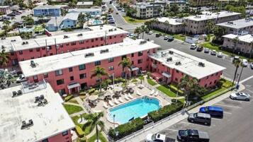 A multi-story hotel with a rooftop pool and a parking lot.