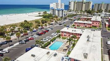 Hotel aan het strand met zwembad, parkeerplaats en uitzicht op de oceaan.