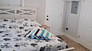 A bedroom with a bed, a ceiling fan, and a white door.