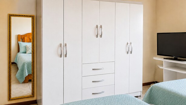 A bedroom with a bed, a wardrobe, a television, and a mirror. - Casa Estrela Cond Fechado c Piscina - RJ (Cabo Frio)