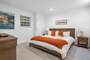 A bedroom with a bed, bedside tables, a desk, and artwork on the walls. - Delray Oasis - Heated Pool+Tiki Bar, 4 Kings (Delray Beach)