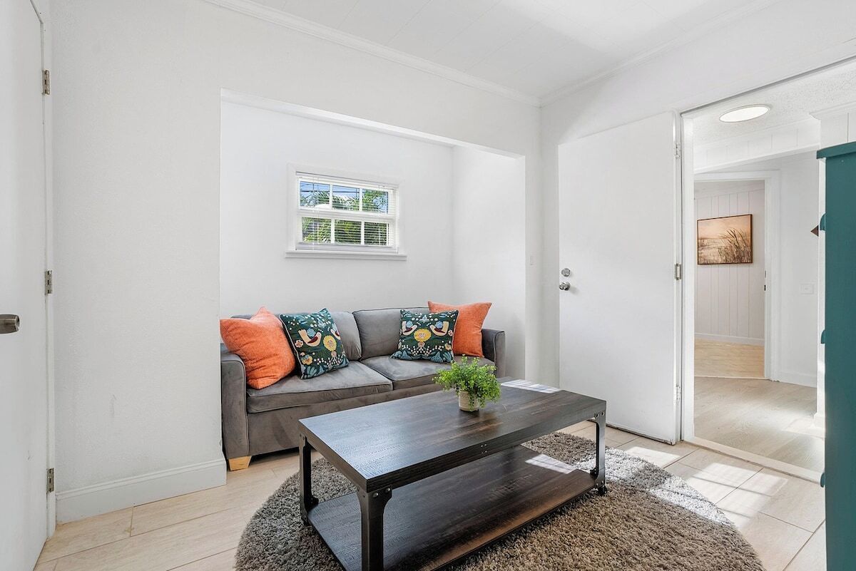 A living room with a sofa, a coffee table, and a window.