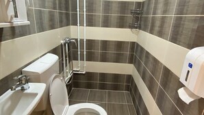 Un baño con inodoro, lavamanos y ducha.