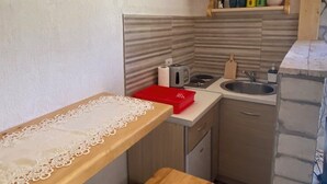 Una cocina compacta con encimera de madera, un lavabo y una estufa.