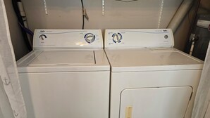 A laundry room with two white front-loading washing machines. - Welcome to the Lake House.  A cozy 2 Bedroom Cottage just steps from the Beach. (Central Elgin)