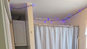 A bathroom with a shower curtain, a toilet, a sink, and a towel rack. - Welcome to the Lake House.  A cozy 2 Bedroom Cottage just steps from the Beach. (Central Elgin)