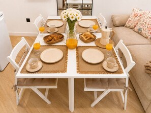 Une table à manger dressée avec des assiettes, des tasses et un vase rempli de fleurs.