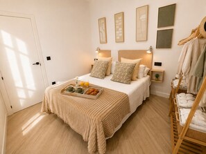 Une chambre d’hôtel avec un lit, des tables de chevet, un plateau avec le petit-déjeuner et un porte-serviettes.