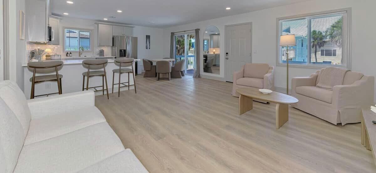 A spacious living area with a kitchen, a dining area, and a seating area with a sofa and chairs.