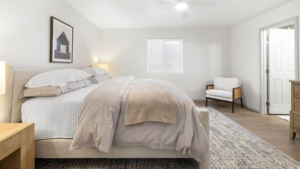 A bedroom with a bed, bedside table, chair, window, and door. - Boise Retreat, New, Hot Tub, Game Room (Ada County)
