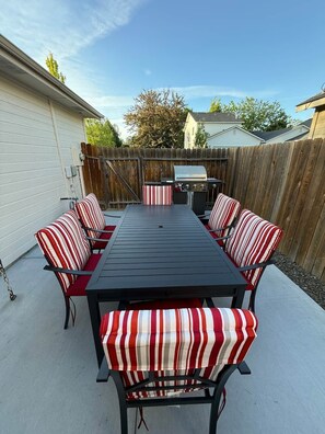 Eine Terrassengruppe mit einem rechteckigen Tisch und sechs gestreiften Stühlen.