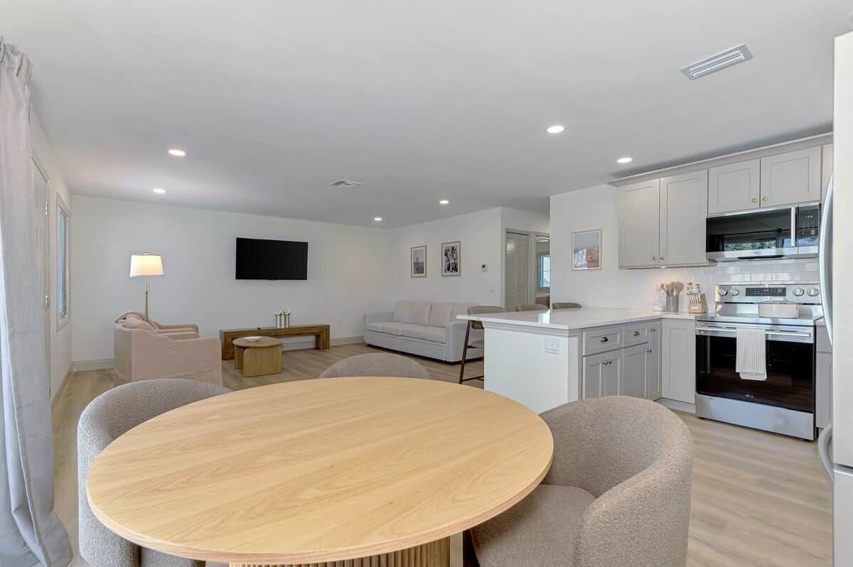 A modern living space with a dining area, kitchen, and seating.