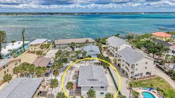 A coastal residential area with houses, a swimming pool, and a view of the ocean.