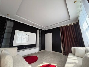A modern living room with a large flat-screen TV, a fireplace, and a red rug. - Elegant Modern Retreat with Stylish Comfort (Shkodër)