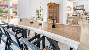 Een eetruimte met een lange tafel, stoelen en een kast.