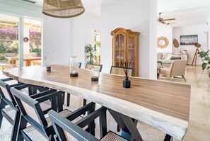 Ein Essbereich mit einem langen Tisch, Stühlen und einem Schrank.