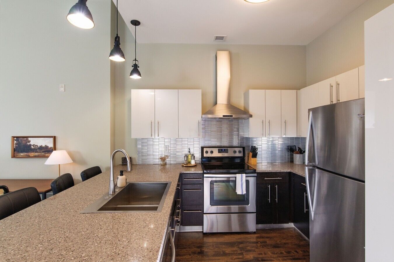 A modern kitchen with granite countertops, stainless steel appliances, and a central island.