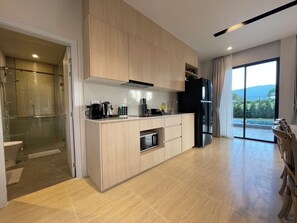 A modern kitchen with a built-in oven, a coffee maker, and a refrigerator.