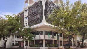 A modern building with a unique architectural design featuring a large, intricate metal facade.
