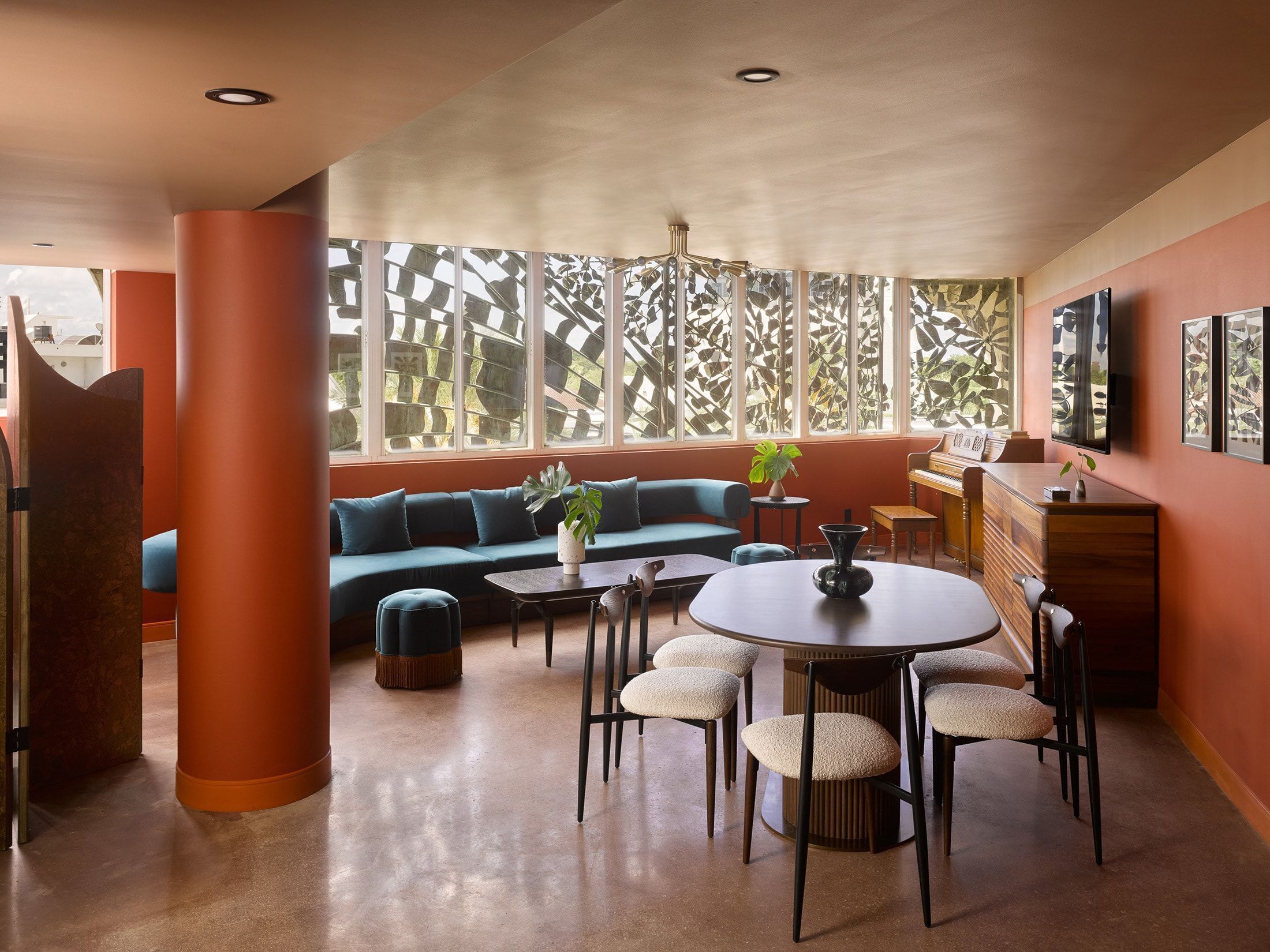 A modern interior with a sofa, dining table, chairs, and a piano.