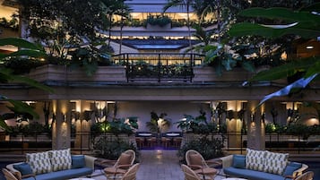 Eine mehrstufige Außenlounge mit Sitzgelegenheiten, einem Pool und üppiger Bepflanzung.
