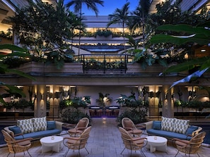 Eine mehrstufige Außenlounge mit Sitzgelegenheiten, einem Pool und üppiger Bepflanzung.