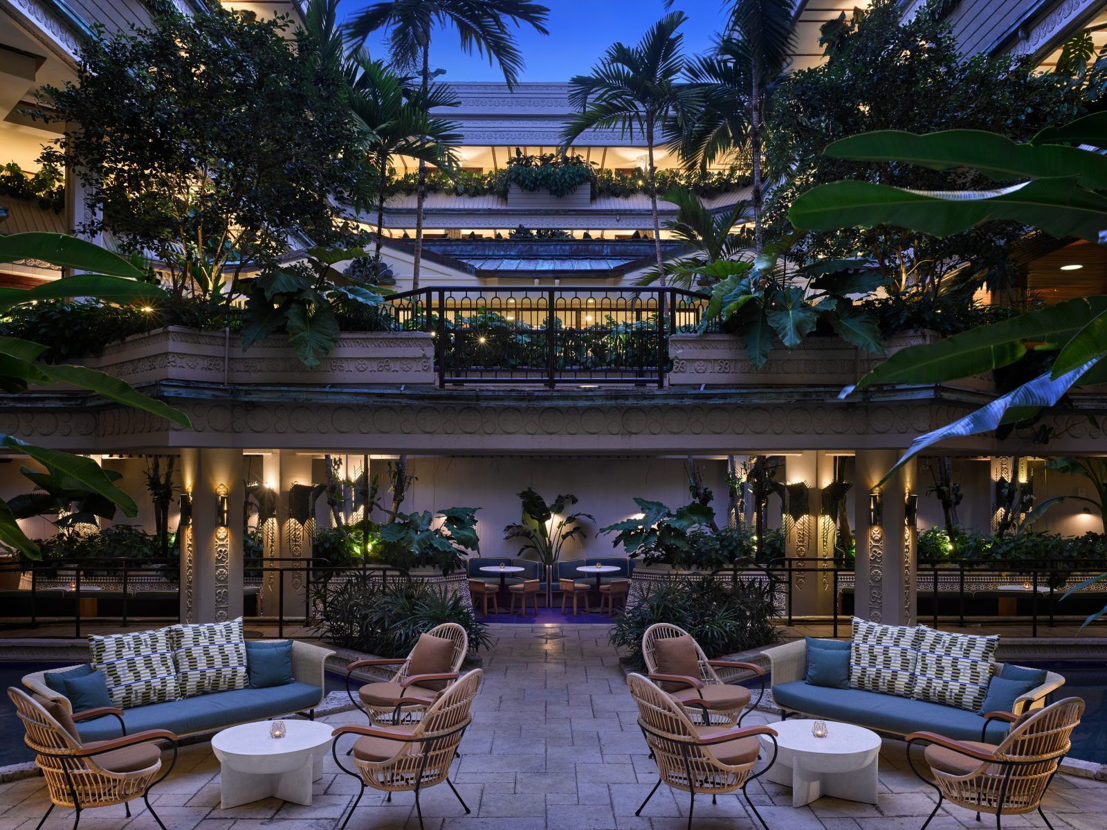 Un espace de détente extérieur à plusieurs niveaux, comprenant des coins salon, une piscine et une végétation luxuriante.