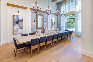 A dining area with a long table, chairs, and decorative vases. - Luxury Home w/ Pool, Hot Tub | Gated Resort (Kissimmee)