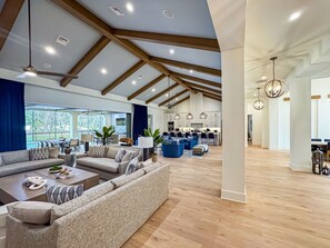 A spacious living area with a large sofa set, a dining area, and a kitchen in the background. - Luxury Home w/ Pool, Hot Tub | Gated Resort (Kissimmee)