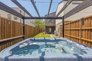 A backyard with a hot tub, wooden fences, and a house in the background. - Dallas Retreat, Mins to DT, Hot Tub & Big Backyard (Dallas)