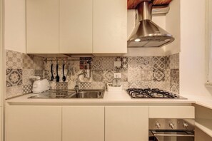 A kitchen with a gas stove, sink, and a toaster. - Charming Roman Home Just Steps from Campo de' Fiori (Roma)