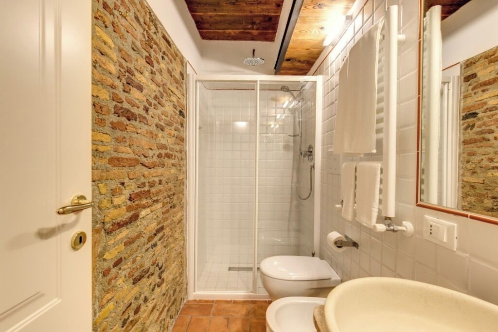 A bathroom with a shower, toilet, and bathtub.