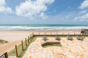 A beachside patio with outdoor seating and a view of the ocean. - Vila Porto by Carpediem In Front of Porto de Galinhas Beach (Ipojuca)