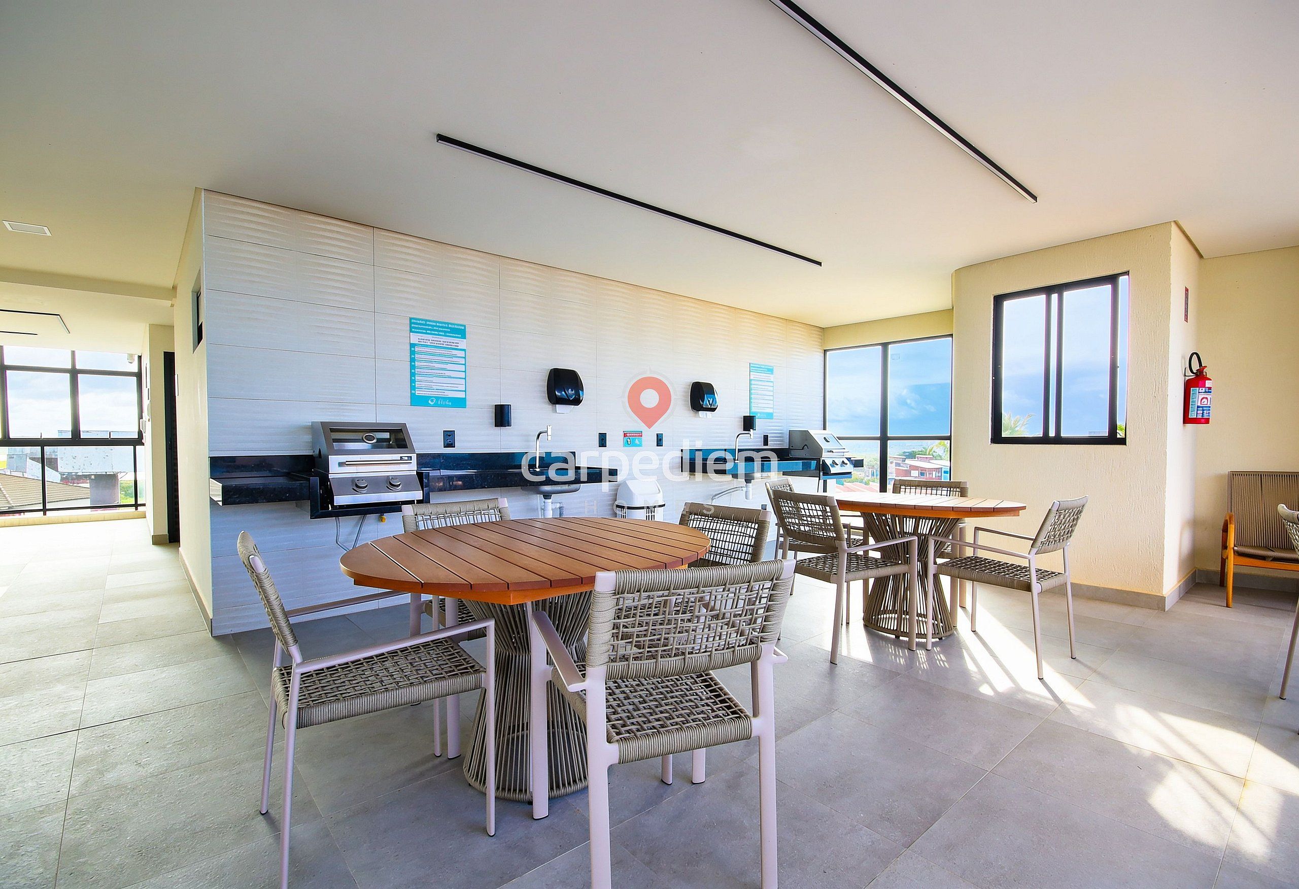 Um espaço de escritório moderno com área de refeições, kitchenette e vista através de grandes janelas.