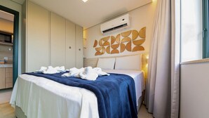 A hotel room with a bed, a wardrobe, an air conditioning unit, and a bathroom visible through an open door. - Vila Porto by Carpediem In Front of Porto de Galinhas Beach (Ipojuca)