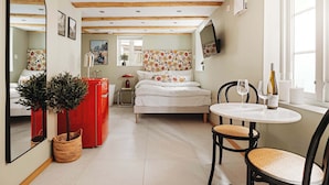 A cozy room with a bed, a small table with glasses, a red cabinet, and a mirror. - 500m to Bryggen • Renovated 2025 • Bathtub Bliss! (Bergen)